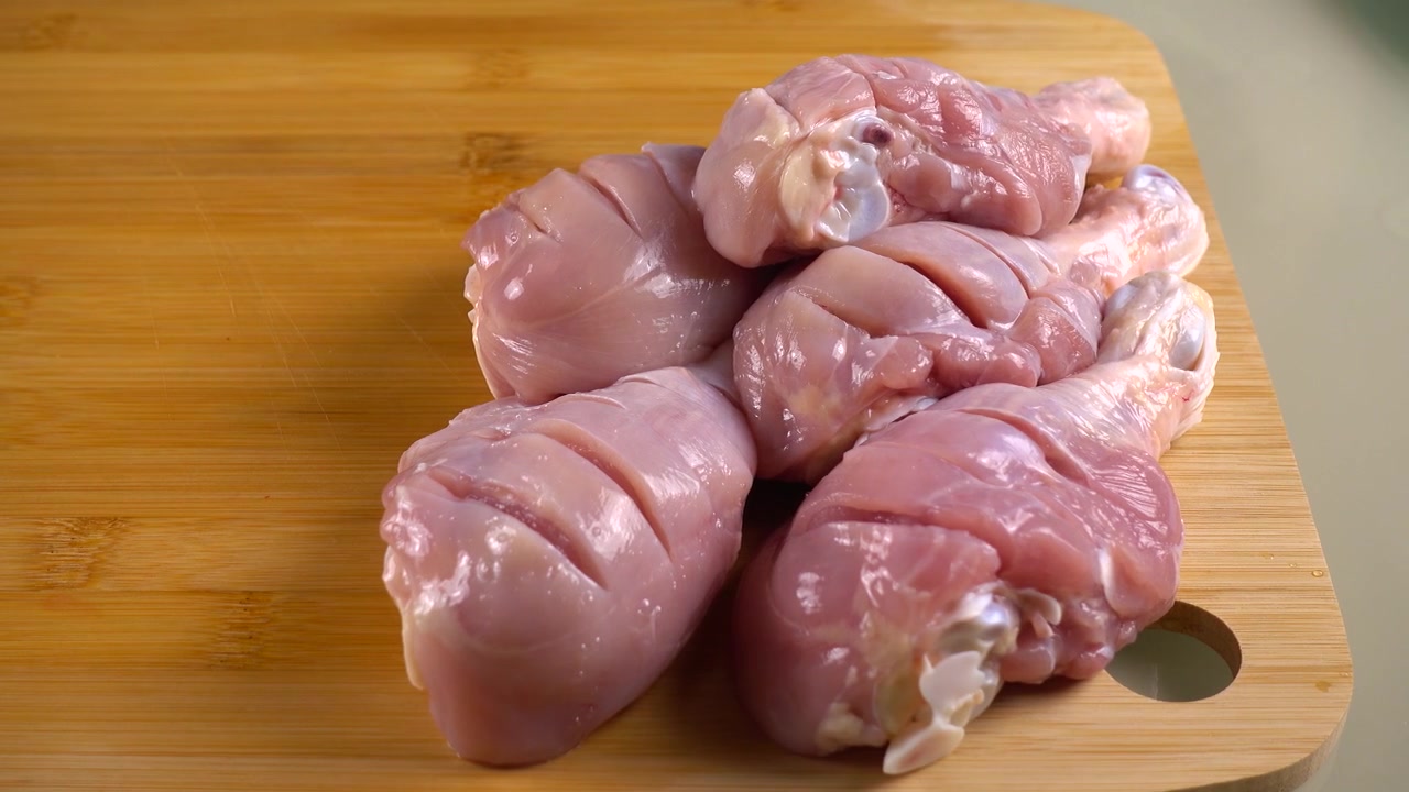 Preparazione di cosce di pollo per la marinatura. Tagli di coltello nella carne