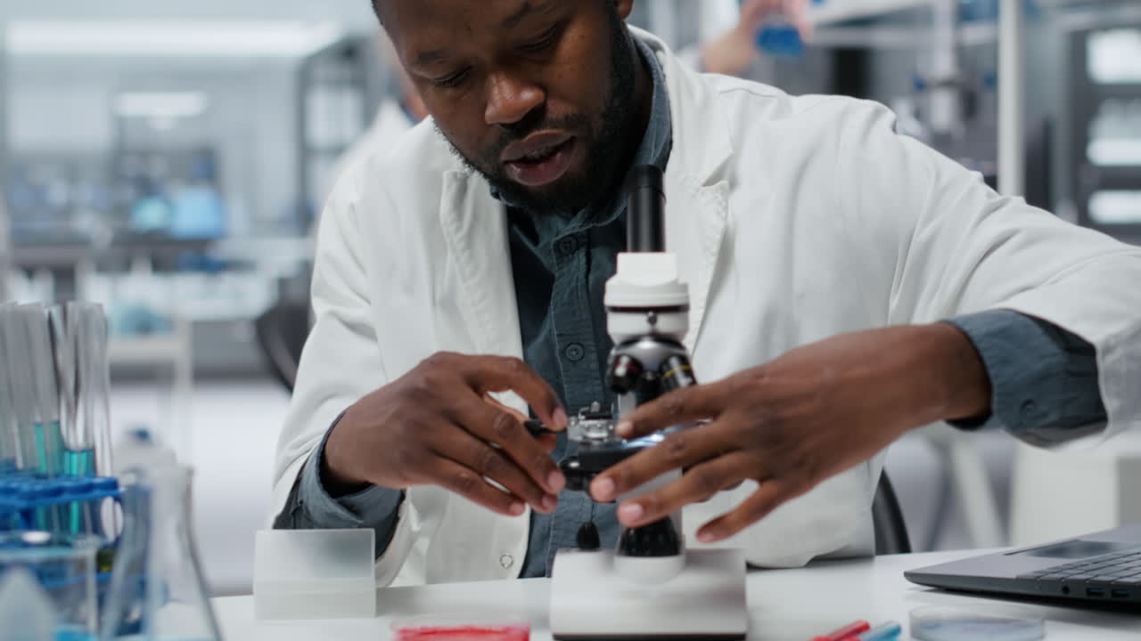 Researcher analyzing genetic samples with high tech microscopic equipment