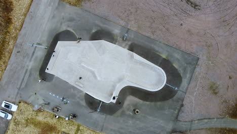 Vista-Superior-De-Un-Skatepark-En-Kållered,-Mölndal,-Suecia-Con-Pocas-Personas-Y-Un-Patinador---Drone-Aéreo