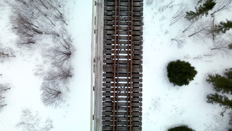 vuelo de drones sobre un puente de tren en invierno con nieve en el suelo