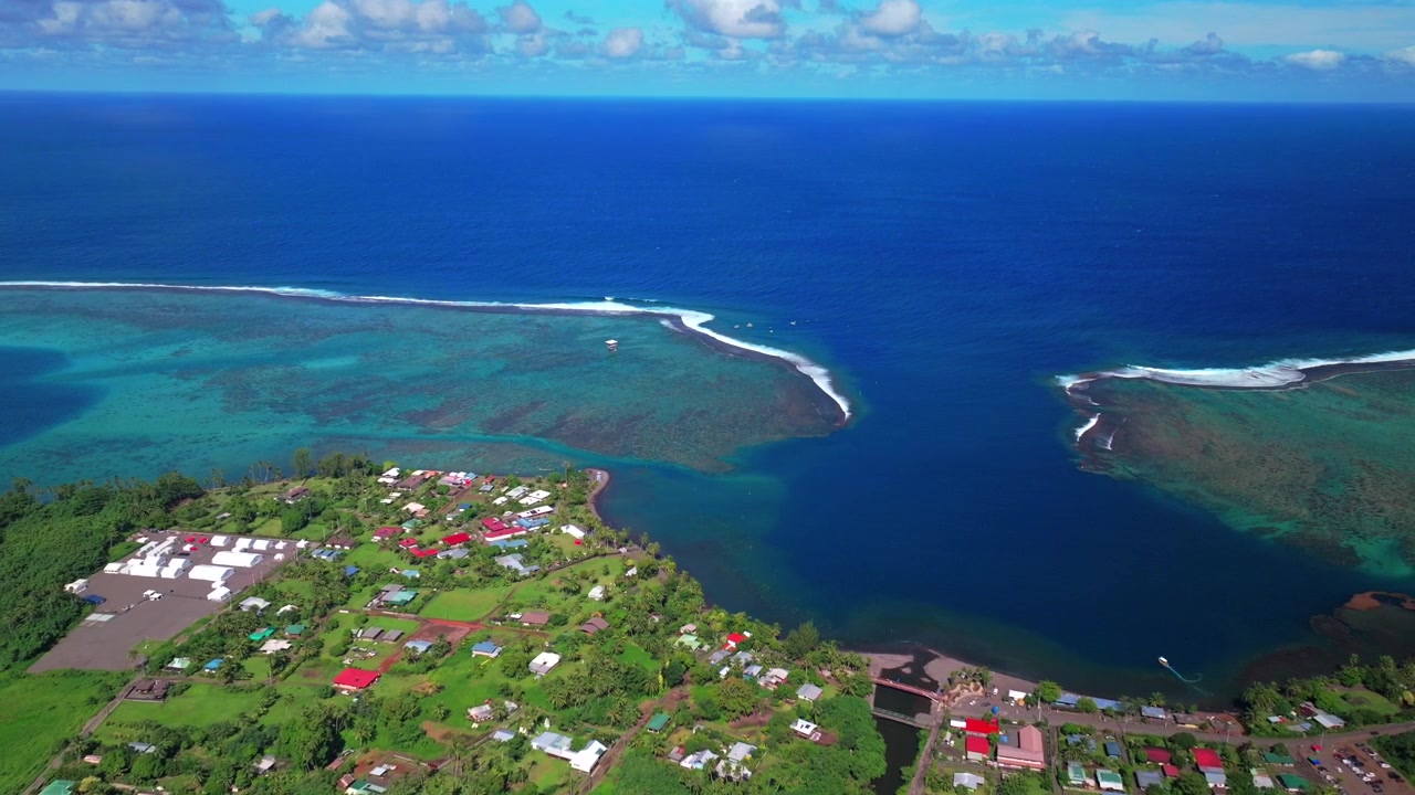 Aerial view town of Teahupo'o village End of the Road Tahiti French Polynesia drone vibrant sunny morning bluesky neighborhood Teahupo'o wave lagoon surfing Passe Havea coral reef Vaiau River downward