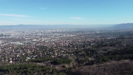 cinematic 4k drone clip flying over vitosha mountain and towards the prosperous suburbs of sofia, bulgaria