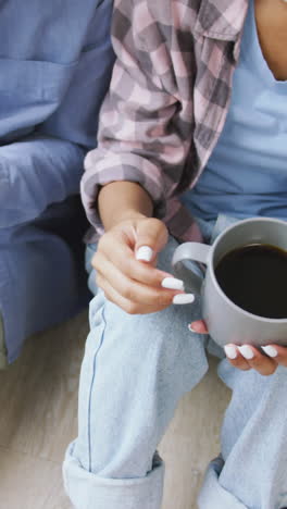 video of midsection of african american couple drinking coffee and talking at home