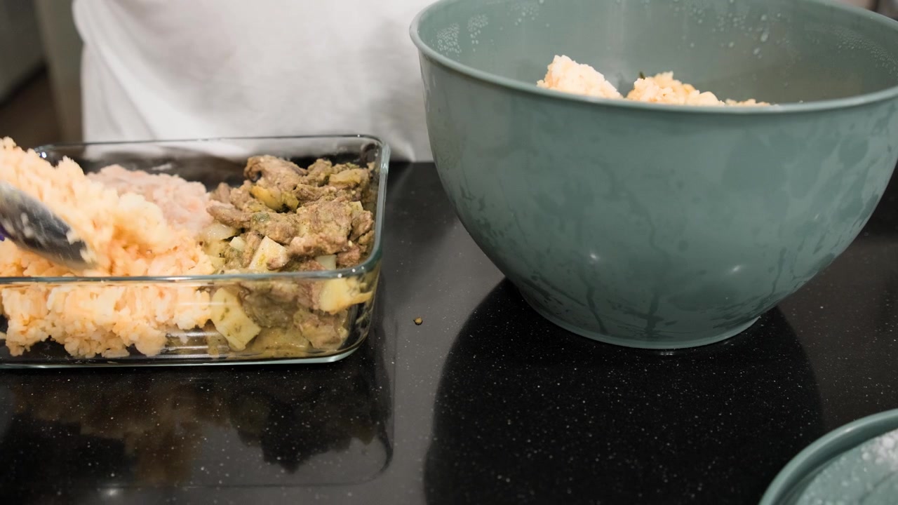Arroz mexicano caseiro sendo porcionado em um recipiente de comida reutilizável durante o preparo de um almoço saboroso para levar