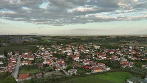 aerial reveals mediterranean, greek katerini village in rural european landscape, houses vehicles around fields