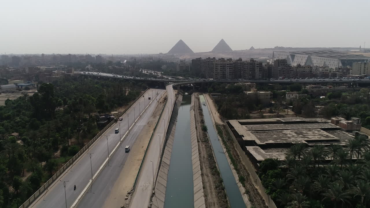 fotografía aérea de las pirámides de egipto en giza junto a una rama del río nilo en el primer plano de la rama de maryotya