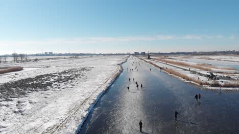 people ice skating on frozen canals in netherlands, 4k winter aerial view