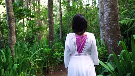 siguiendo a una mujer caminando por el bosque