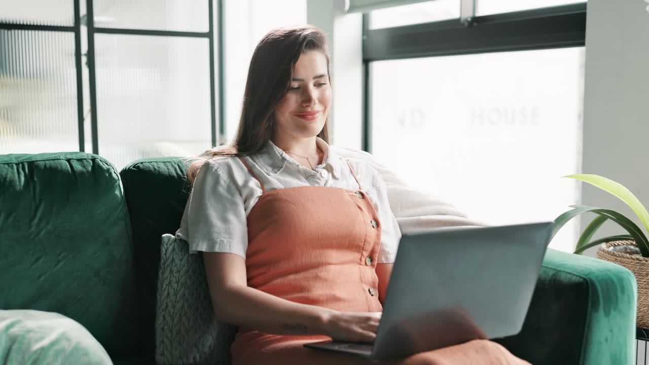 mujer trabajando en una computadora portátil en el sofá en casa