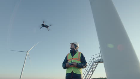 engineer inspecting wind turbines with drone