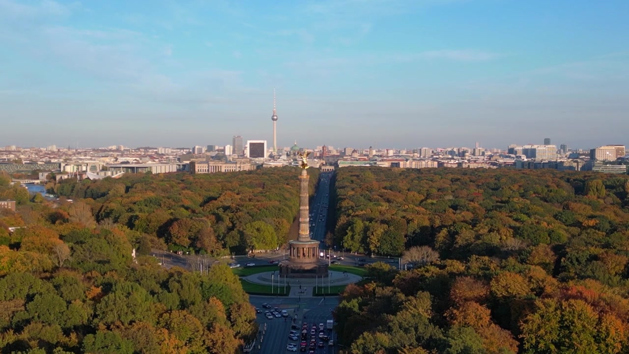 Ikonisk vartegn omgivet af farverigt efterårsløv med bybilledet i baggrunden under en klar blå himmel. Perfekt luftfoto, panoramaudsigt fra drone.
