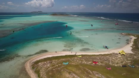 Kitesurfer-Auf-Vapor-Cay-In-Los-Roques,-Venezuela-Mit-Leuchtend-Blauem-Wasser,-Luftaufnahme