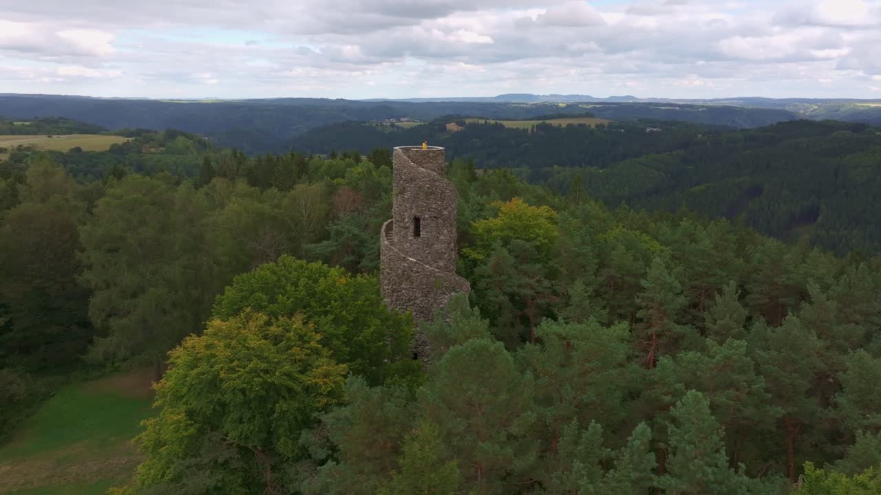 Aerial of Krasno's spiral tower surrounded by forest and landscape, Czech