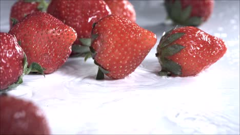 strawberries rolling down on white background. slow motion
