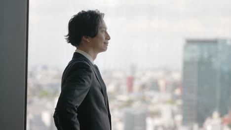 창문 에 서 있는 아시아 사업가 의 초상화