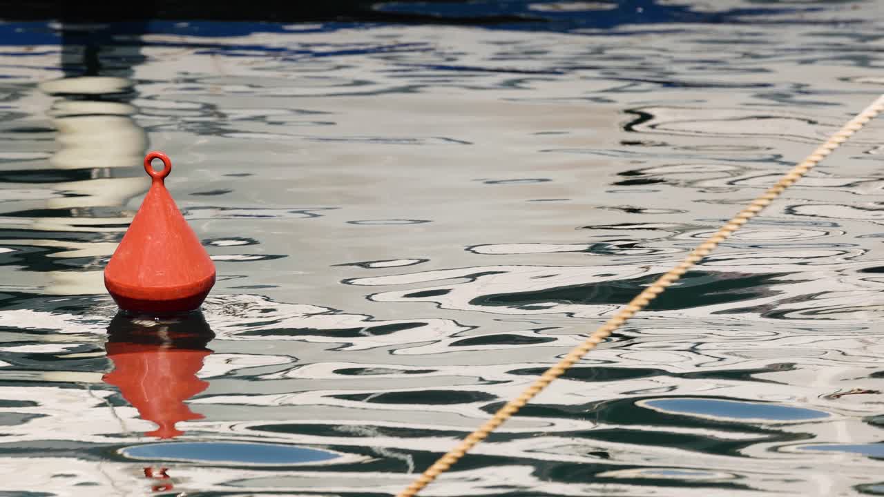 Red buoy floating on calm water