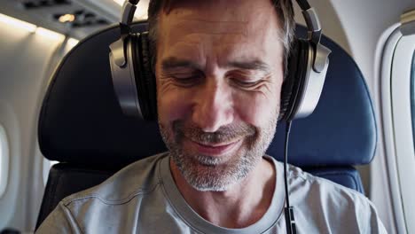 hombre escuchando música en el avión