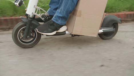 close up man rides a electric scooter on the road to deliver orders and packages for customers