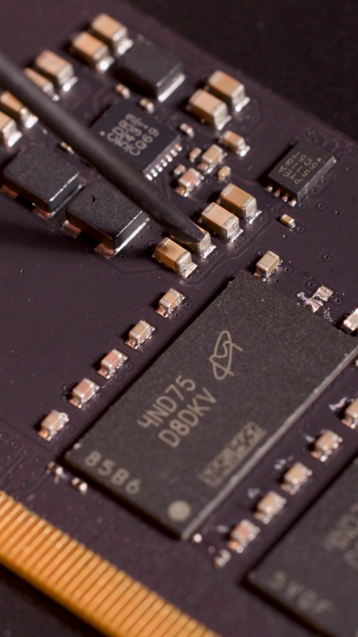 Technician Using Probe to Inspect Electronic Circuit Board Components