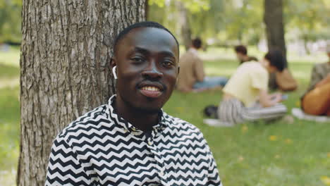 Retrato-De-Hombre-Afro-En-Auriculares-Inalámbricos-En-El-Parque