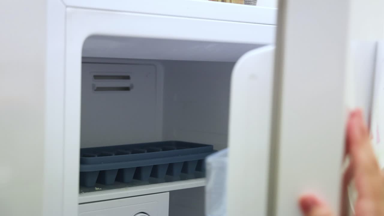 손은 아이의 그림으로 냉장고 문을 닫습니다.