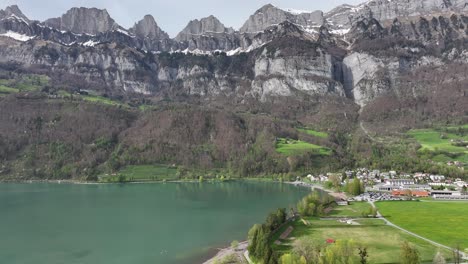 Lush-lakeside-view-of-Walensee-with-Churfirsten-backdrop,-Swiss-splendor---aerial-panoramic