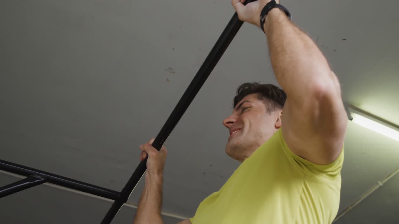 vista lateral de cerca de un hombre atlético caucásico haciendo chin ups