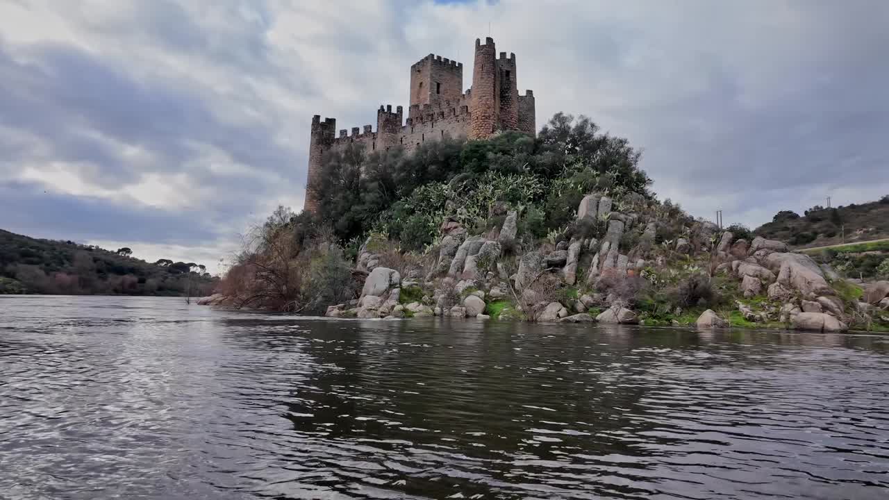 Vista serena del Castello di Almourol da una barca su un fiume calmo in Portogallo