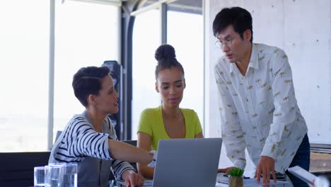 Muti-ethnic-business-colleagues-discussing-over-laptop-in-a-meeting-at-modern-office-4k