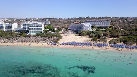 aerial view of a holiday resort sandy beach, with beach umbrellas and sun beds