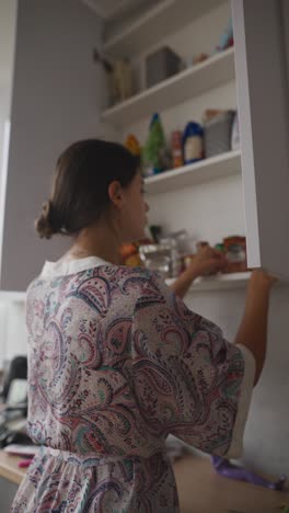 woman organizing kitchen cabinets