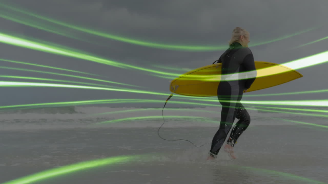 Senior woman carrying yellow surfboard walking into surf, showing technology data lines overlay