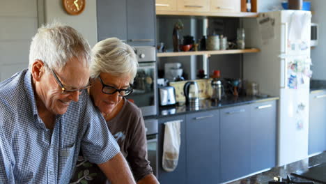 senior couple interacting each other in kitchen 4k