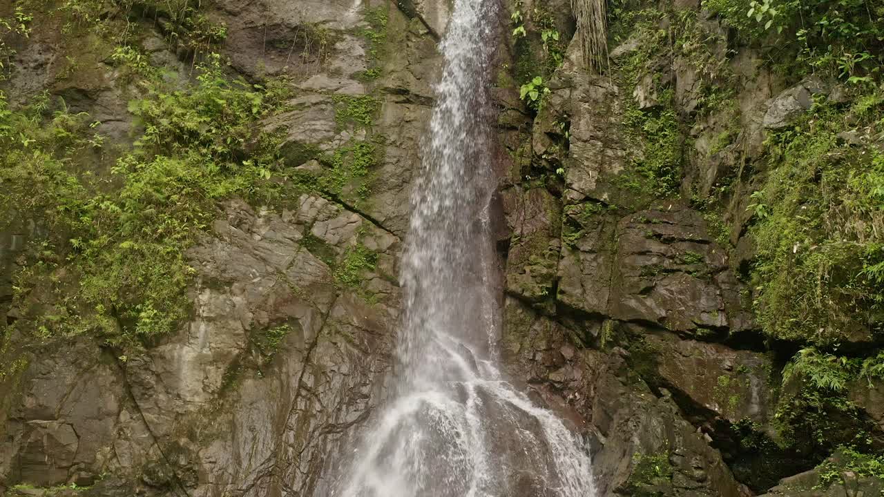 tomada de bajo ángulo de la remota cascada de lumondo, en lo profundo de la jungla de alegría, surigao del norte, filipinas en un día nublado