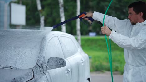 person washing a car with foam