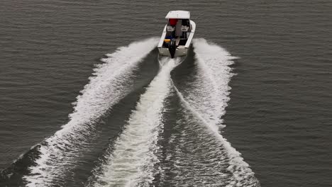 Eine-Luftaufnahme,-Die-Einem-Kleinen-Weißen-Boot-In-Einer-Salzwiese-Vor-Der-Südküste-Von-Long-Island,-New-York,-An-Einem-Bewölkten-Tag-Folgt