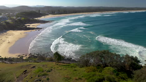 wide revealing drone shot of coastline and rock outcropping at cabarita beach australia