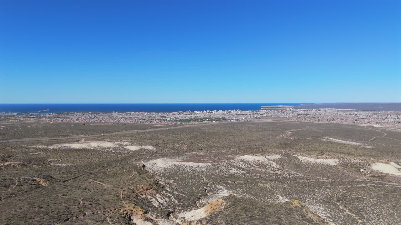 Arid landscape of coastal Patagonia with city of Puerto Madryn and ocean, Argentina