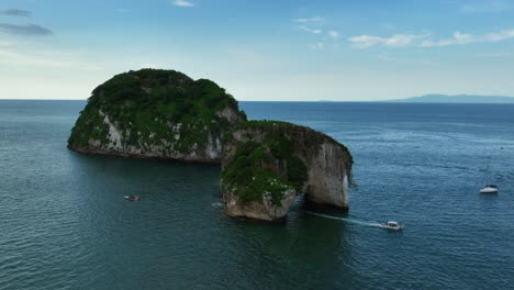 Vista-Aérea-De-Un-Barco-Conduciendo-A-Través-De-Los-Arcos-De-Misalyoa-En-Puerto-Vallarta,-México.