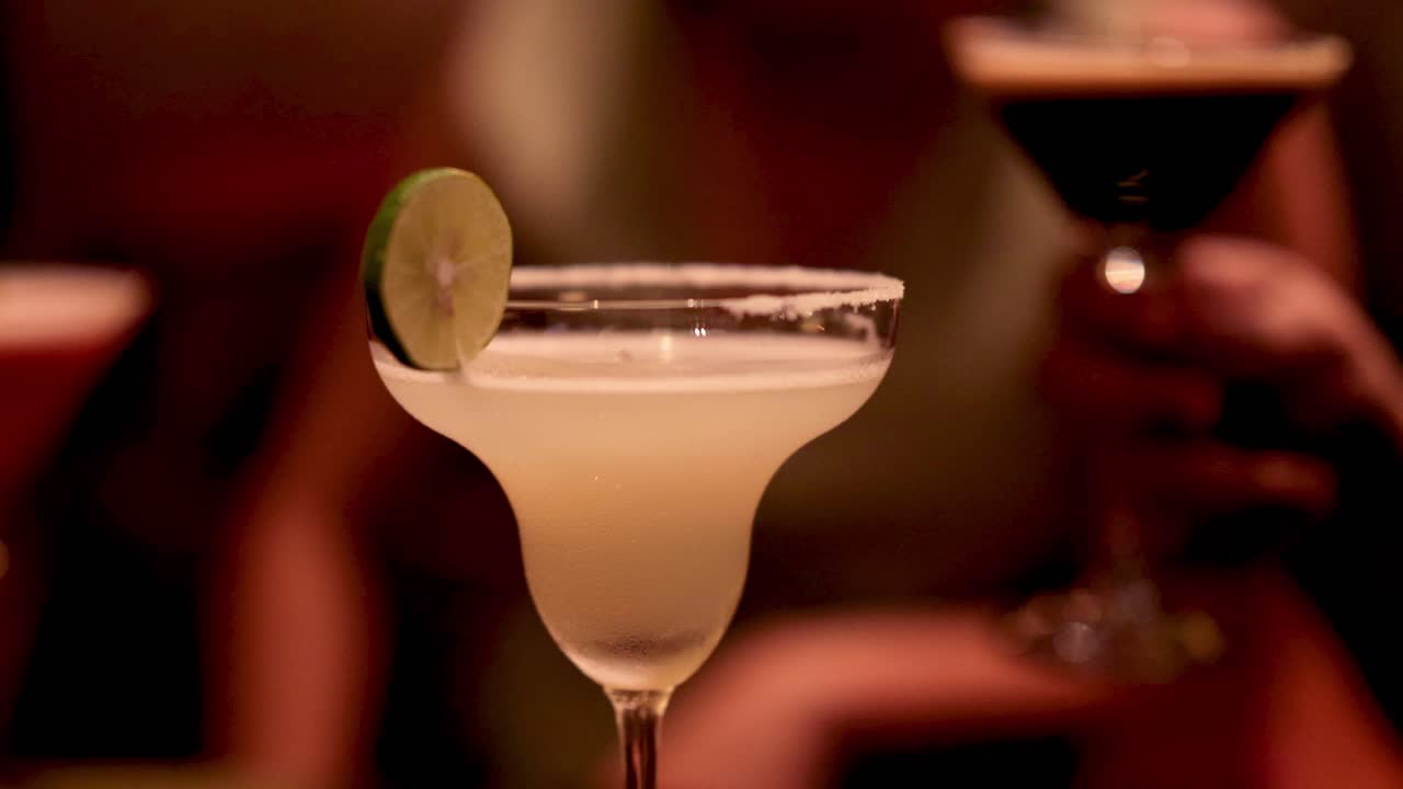 dos cócteles sonando en un bar débilmente iluminado