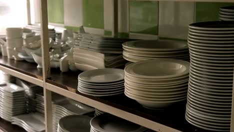 there are many different white plates in the restaurant kitchen.