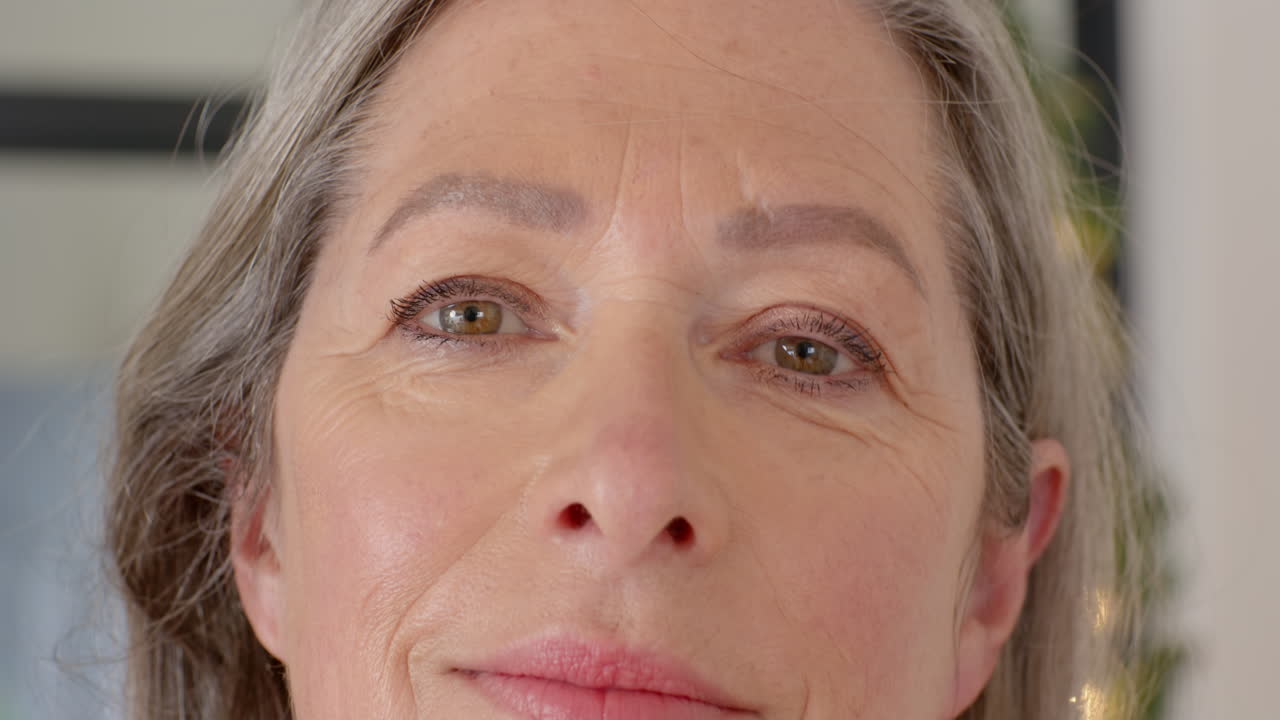 Mature woman smiling peacefully at home, enjoying moment of relaxation