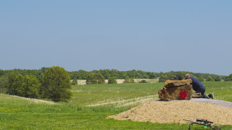 un tirador atento apuntando un rifle a un partido de precisión en leach, oklahoma.