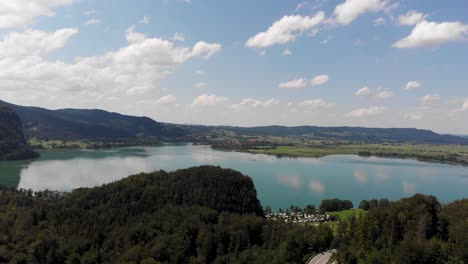 a drone shot of a lake by the forest in germany