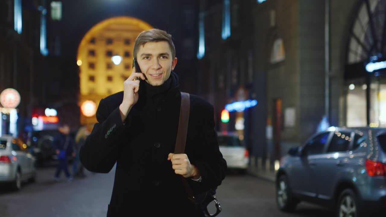 밤의 도시를 배경으로 전화 통화하는 청년 2