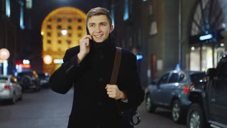 Young-man-talking-on-the-phone-against-the-backdrop-of-a-night-city-2