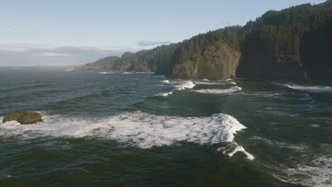 aerial dolly of cape perpetua's rocky coastline on the oregon coast, with waves breaking against the cliffs
