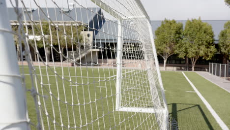 soccer goal net on field, focusing on empty goal and green grass