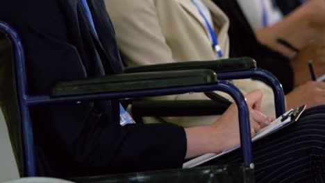 businesswoman writing on a notepad in a business seminar 4k