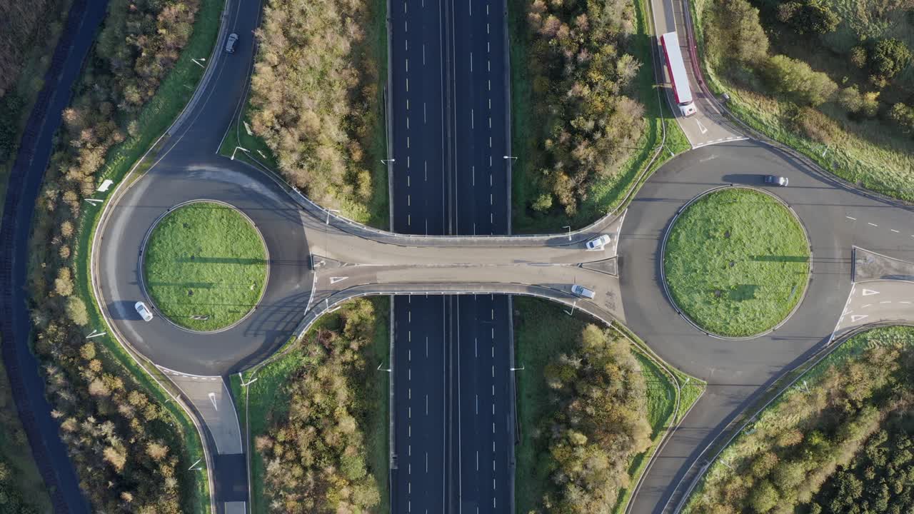 Vertical aerial timelapse of highway roundabouts and motorway traffic